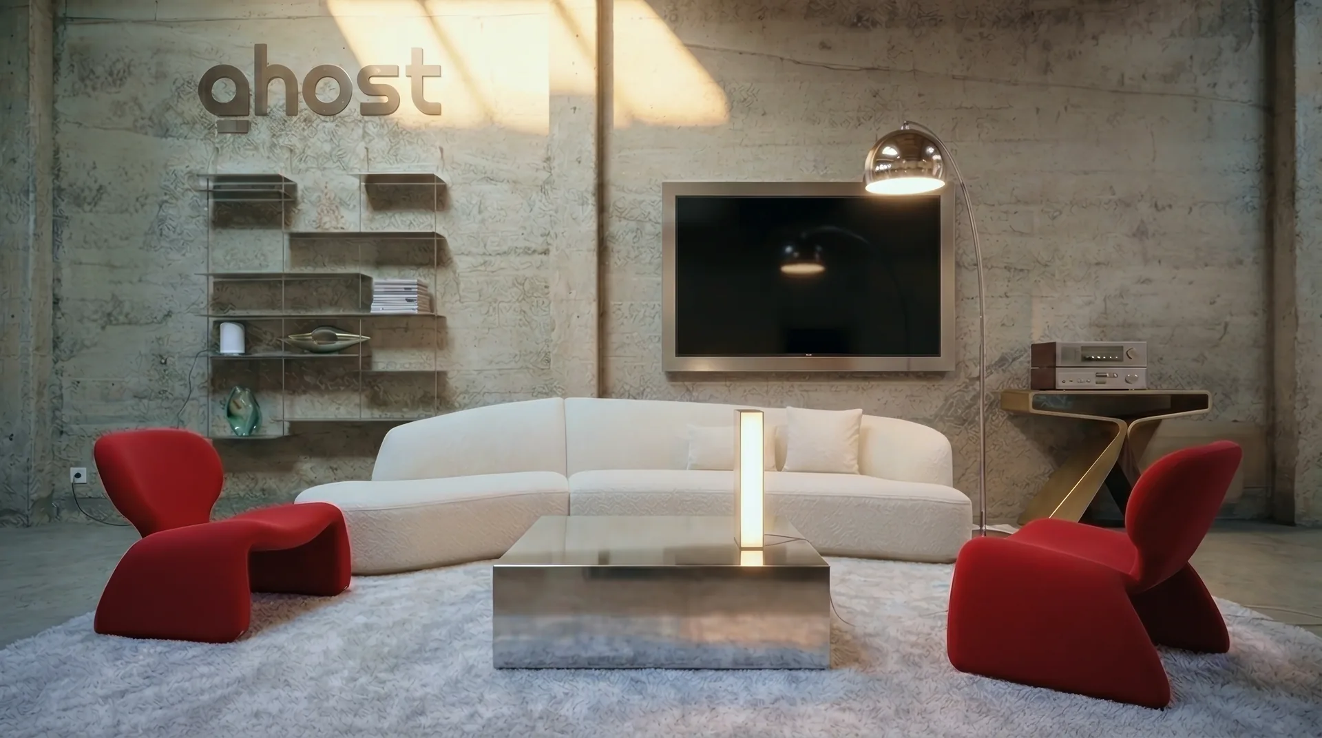 A concrete living room: the ghost logo on the wall, a white sofa and red chairs, Core glowing on the low table